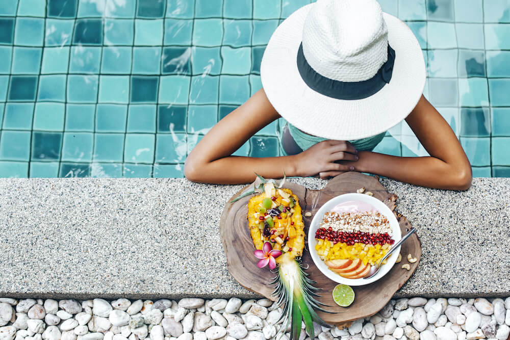 women relaxing poolside with fresh fruit