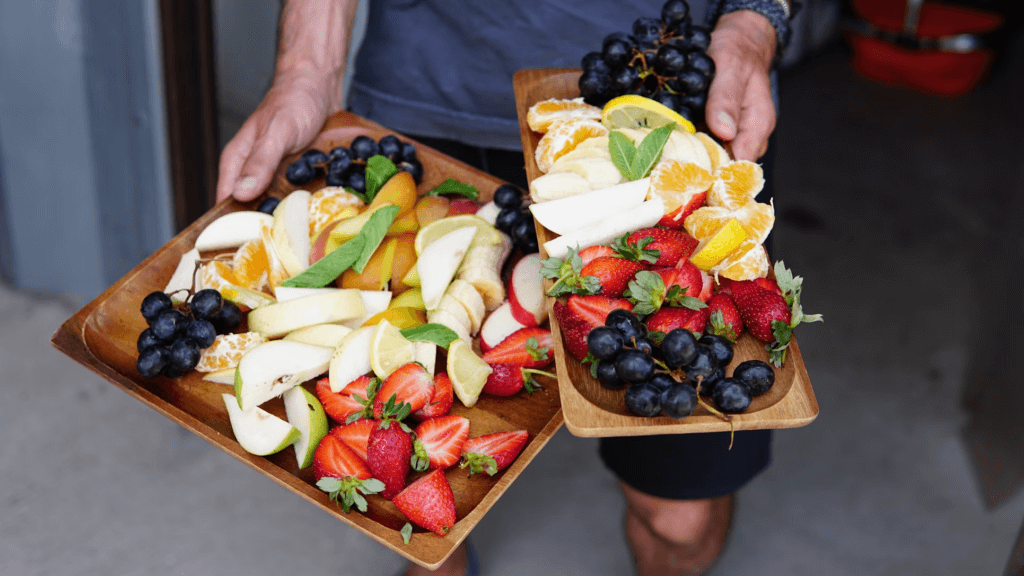 person holding two charcuterie fruit boards