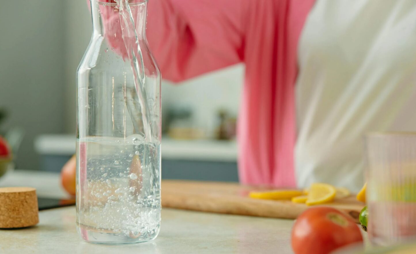 Person Pouring Water Into Pitcher